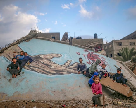 Children surrounded by damaged buildings in Gaza