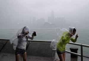 People brave the wind on the waterfront at Victoria as typhoon Haima approaches Hong Kong
