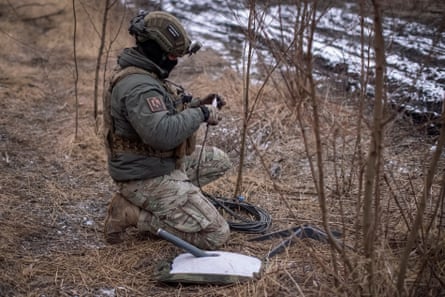 A Ukrainian serviceman prepares a Starlink satellite at his positions at the frontline.