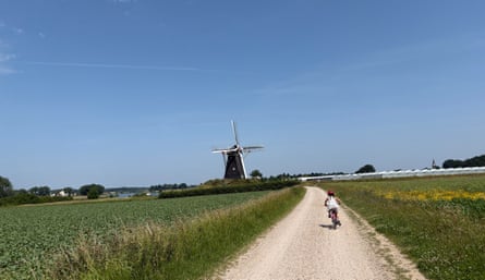 Young cyclist on a track heading to a windmill