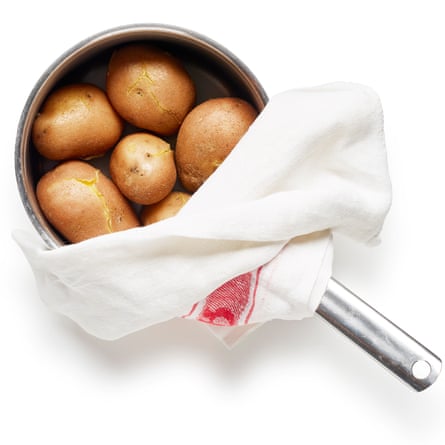 Bring the unpeeled potatoes to a boil, cook, then drain and cover with a tea towel, so they steam. Photos by Dan Matthews.