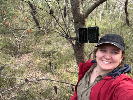 A selfie by Bianca McBryde who is setting up a device on a tree trunk