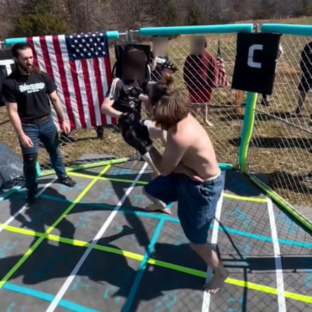 a man watches two minors fight each other