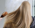 Healthy shiny long blonde hair brushed by stylist in modern salon.