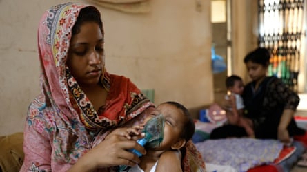 A female holding an oxygen disguise connected to nan look of a small, crying child