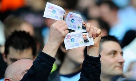 Manchester City fans wave fake £500m notes at the Chelsea fans before their game in 2008. It was the first game after the club was bought by the Abu Dhabi United group.