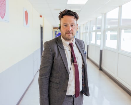 Mr Burton from Educating Yorkshire stands in a corridor in school