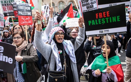 Protesters carry banners and wave Palestinian flags.