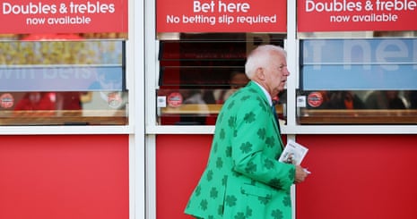 ऐंट्री में शेमरॉक सूट पहने एक रेसगोअर।