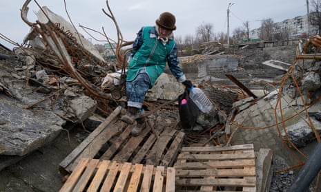 Ludmila crosses a destroyed bridge amid artillery shelling in Bakhmut, Ukraine.