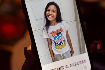 A young girl smiling in a picture displayed on a phone