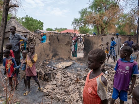 People walk among the devastation in Nyriol county