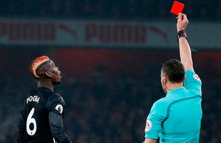 Referee Andre Marriner shows a red card to Paul Pogba.