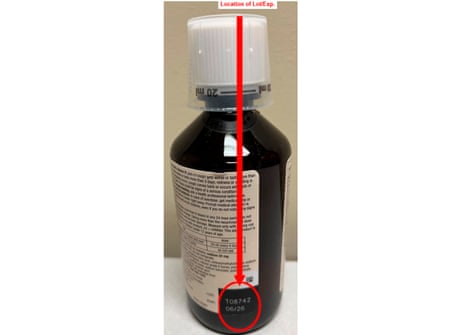 bottle of cough syrup with a red arrow and a circle around the lot number