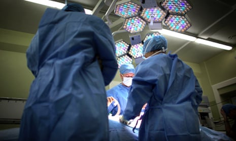 A surgeon and theatre team perform an operation