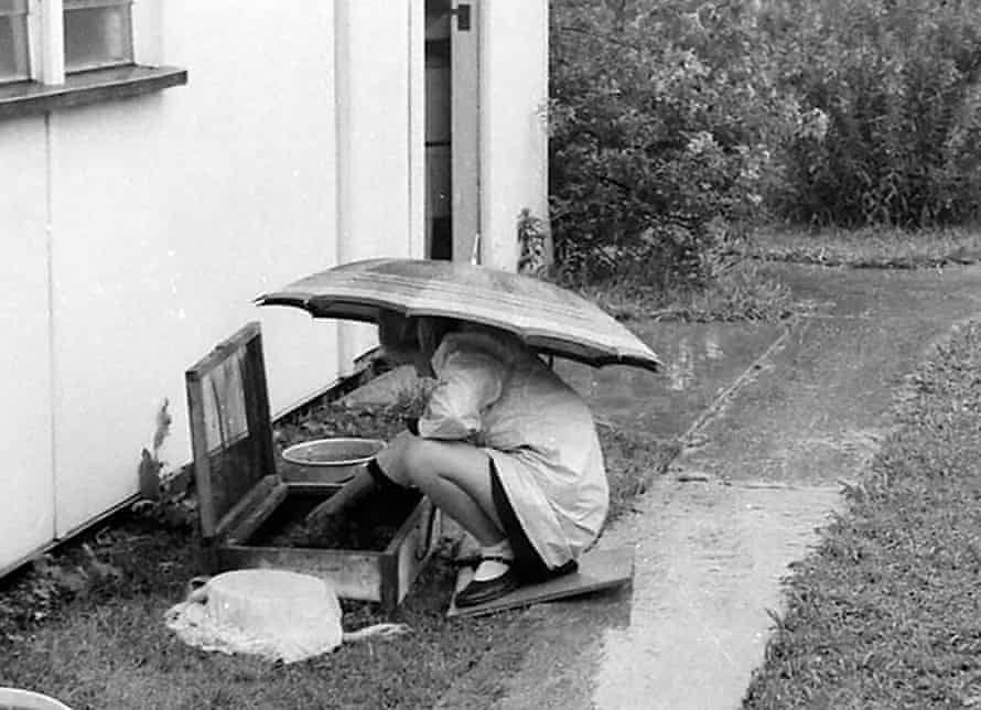 Marion aged nine in her home garden, with containers of tadpoles