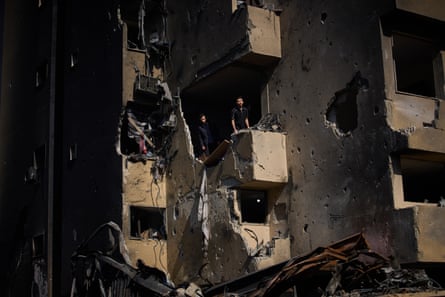Men inspect the damage to their Beirut apartment building after it was hit by an Israeli airstrike a