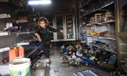 A Palestinian child holds a chocolate bar inside a damaged shop after an attack by Israeli settlers the previous night, 14 April, in the West Bank village of Qusra, near Nablus.