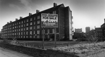 Block of flats with for sale sign in front of it