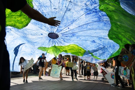 students wave a parachute with the earth painted on it