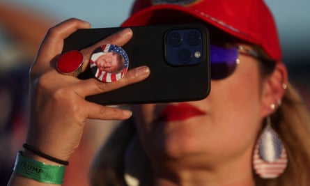 A supporter of former U.S. President Donald Trump uses her phone during his first campaign rally