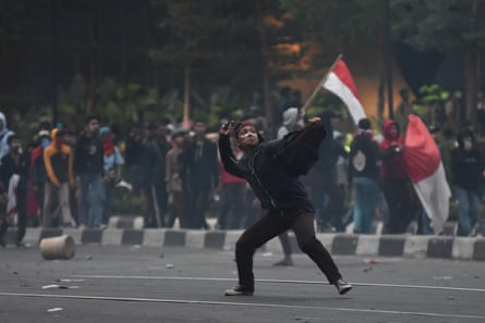 A protester throws a stone during clashes with police in Jakarta.