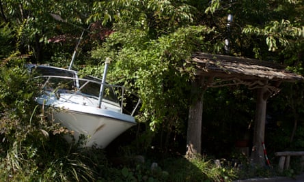 The bow of a motorboat pokes out of the undergrowth after being left where it is for four and a half years in the town of Naraha