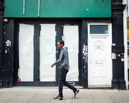 A man walks past an empty shop in London