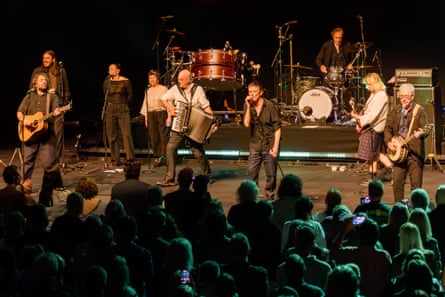 A large crowd watches on as Fearnley, Stacy and Jem Finer lead the band in one of their songs