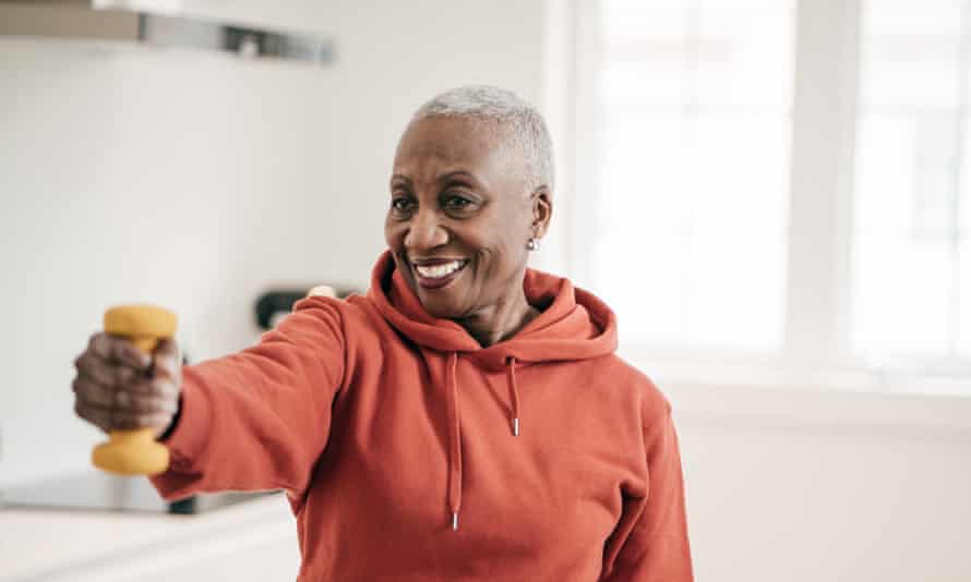 Woman exercising with dumbbell at home