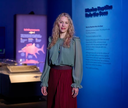 Kate Whittington standing in front of exhibition information panels at the Natural History Museum.