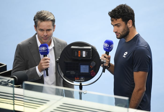 Italy’s Matteo Berrettini, right, is interviewed by former Australian player Todd Woodbridge after he withdrew from his fourth round match against Greece’s Stefanos Tsitsipas with an injury.