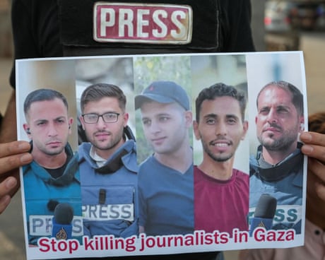 A Syrian journalist holds a picture of dead Palestinian journalists during a protest against the killing of journalists in the Gaza Strip, 11 August 2025