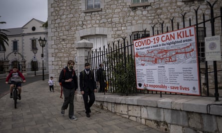 Schoolchildren walk by a Covid-19 information banner in Gibraltar.