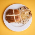 A Sainsbury’s Taste the Difference apple & cinnamon hot cross bun, sliced, toasted and buttered, on a white plate