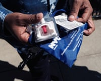 close up of a pair of hands holding a naloxone cut