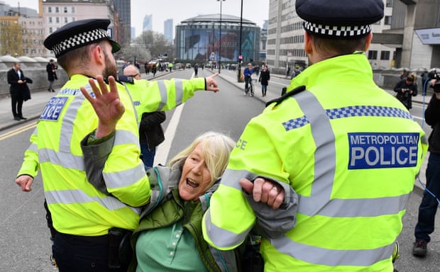 Police officers remove an Extinction Rebellion activist from Waterloo Bridge.
