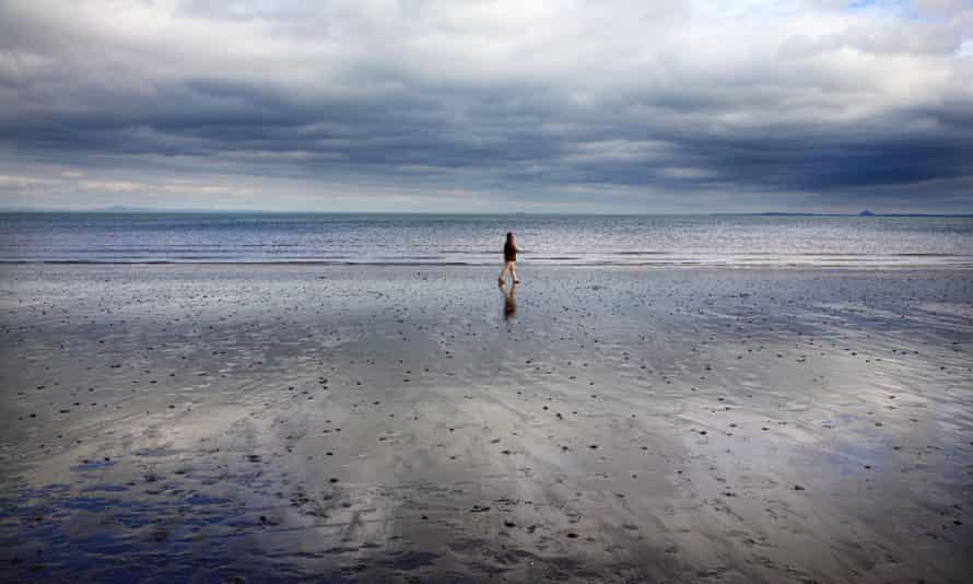 A man walking on Portobello beach in Edinburgh.