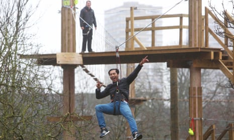 A visitor slides down a zipwire at the Go Ape experience which has just opened in Battersea Park. 
