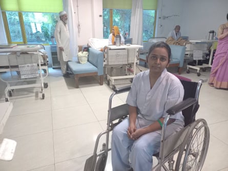 A young Indian woman sits in a wheelchair in a hospital ward