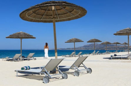 A white sand beach with umbrella sun shades and sunbeds