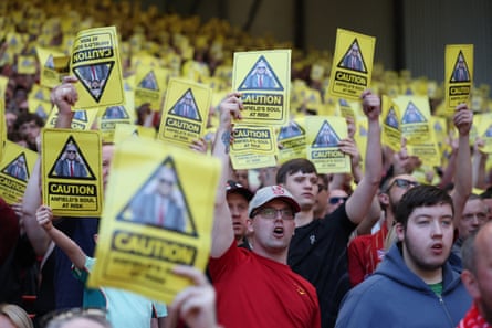 Liverpool fans hold up yellow cards in protest against the ticket price increase