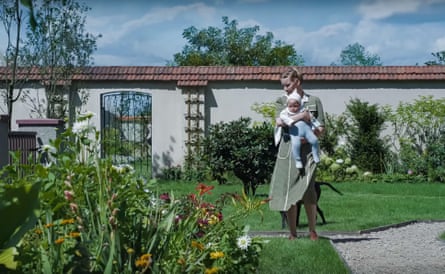 A woman in a garden holding a baby
