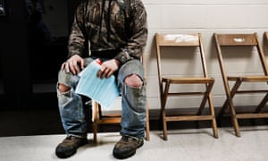 A man waits at dawn, after sleeping in his car, to see a free ‘mobile doctor’ in Olean, New York.