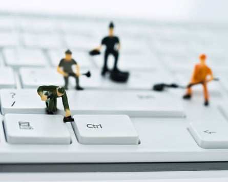 A group of figurines cleaning and fixing computer keyboard