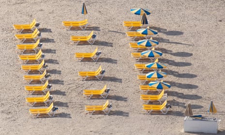 Rows of empty sunloungers on a beach in Gran Canaria, Spain.