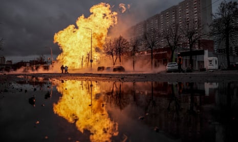 Firefighters work to extinguish a fire near a car dealership after a missile strike in Kyiv, Ukraine, 02 January 2024, amid the Russian invasion. A huge flame is seen rising into the air in front of a tower block.