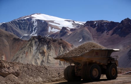 A truck carrying a pile of sediment drives through an opencast mine.