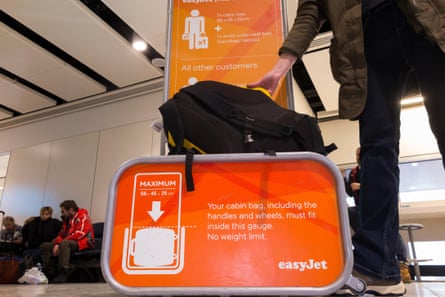 A person checking if the size of their bag will fit the required size limit in an airport