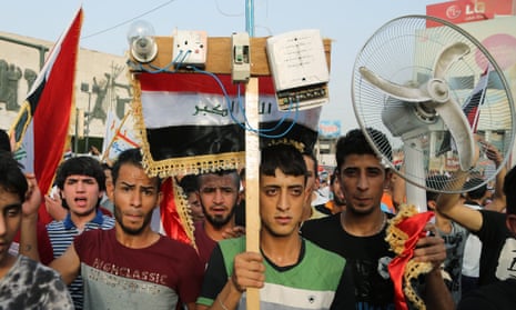 Protesters carry national flags and a fan in Baghdad on Friday